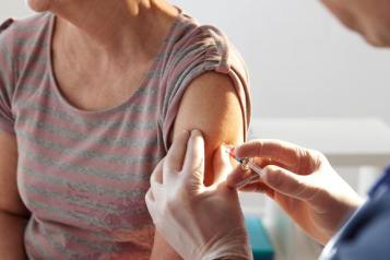 Doctor giving a female a flu injection.